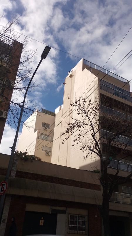 Edificio con medianera recién pintada mediante acceso por cuerdas