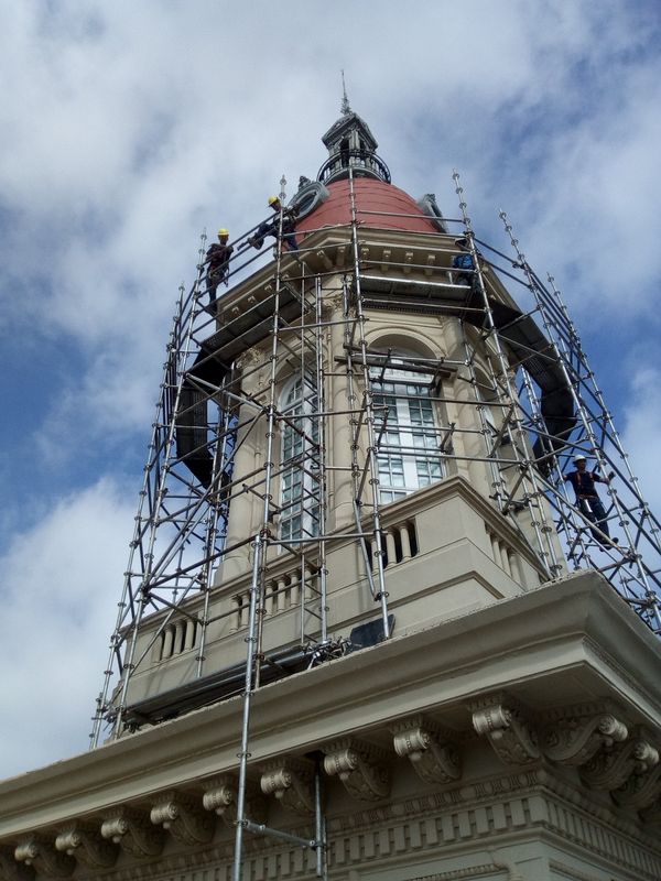 Técnicos trabajando en altura sobre el andamio de la cúpula del edificio La Inmobiliaria